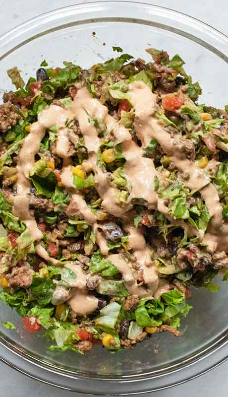 Add the dressing the Doritos taco salad.