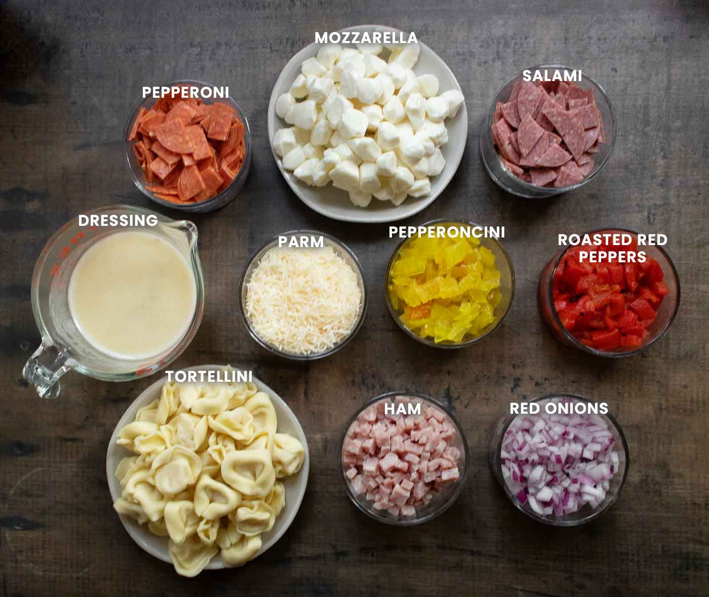 Prepared ingredients for the pasta salad arranged on a board.