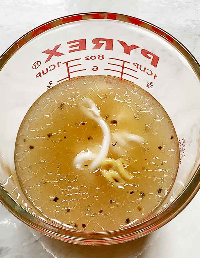 Dressing ingredients in a glass measuring cup.