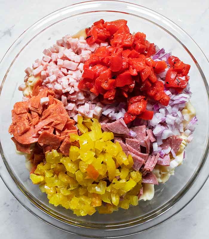 Adding meats and veggies to the bowl.