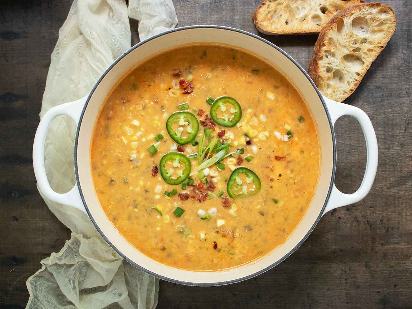 A pot of Jalapeno Bacon Corn Chowder with slices of toasted bread on the side.