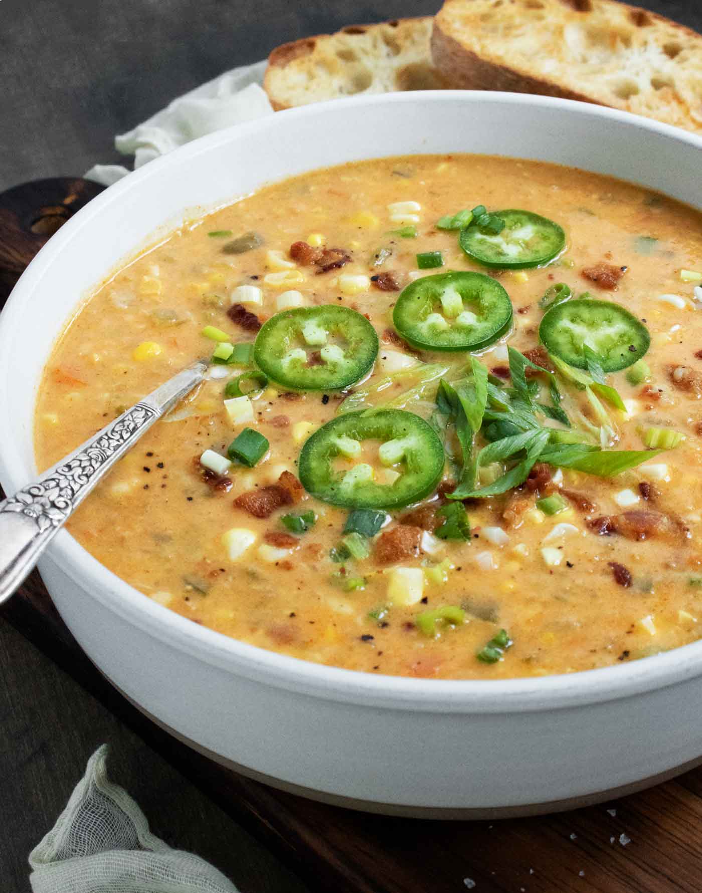 Side-angled view of a bowl of Jalapeno Bacon Corn Chowder with a spoon.