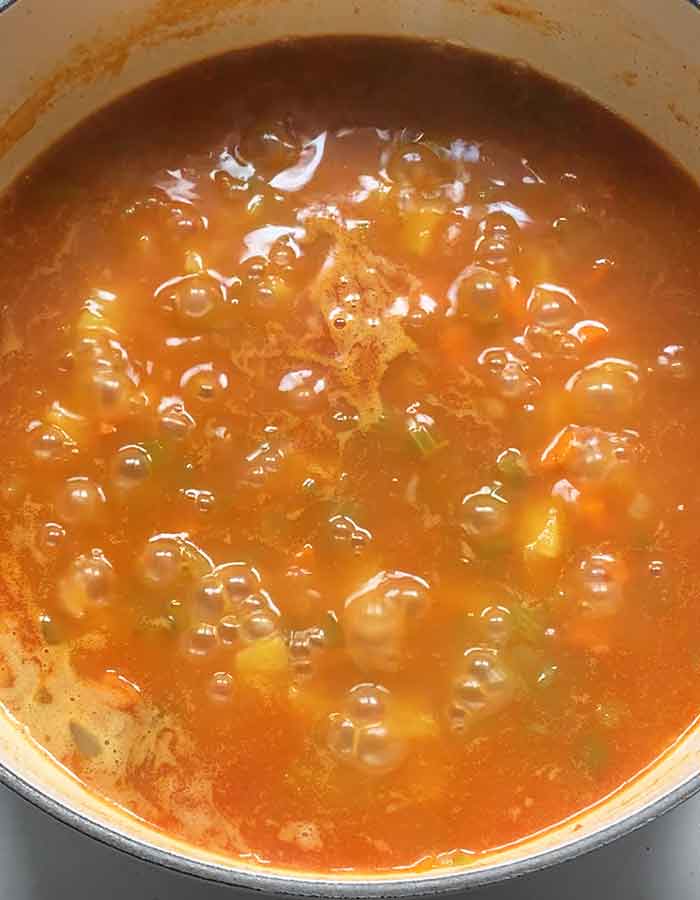 Simmering the soup until the potatoes are cooked through.