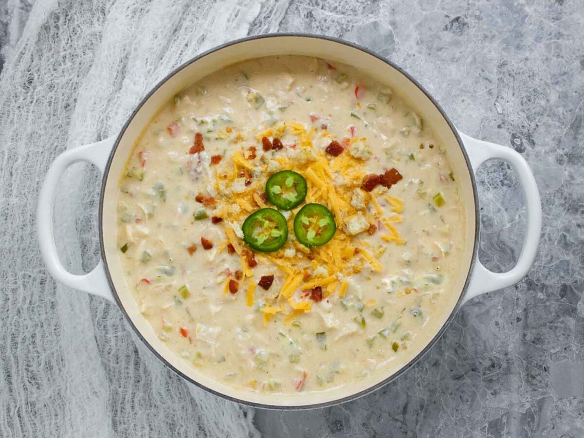 Overhead view of Jalapeno Popper Chicken Soup in a large white Dutch oven.