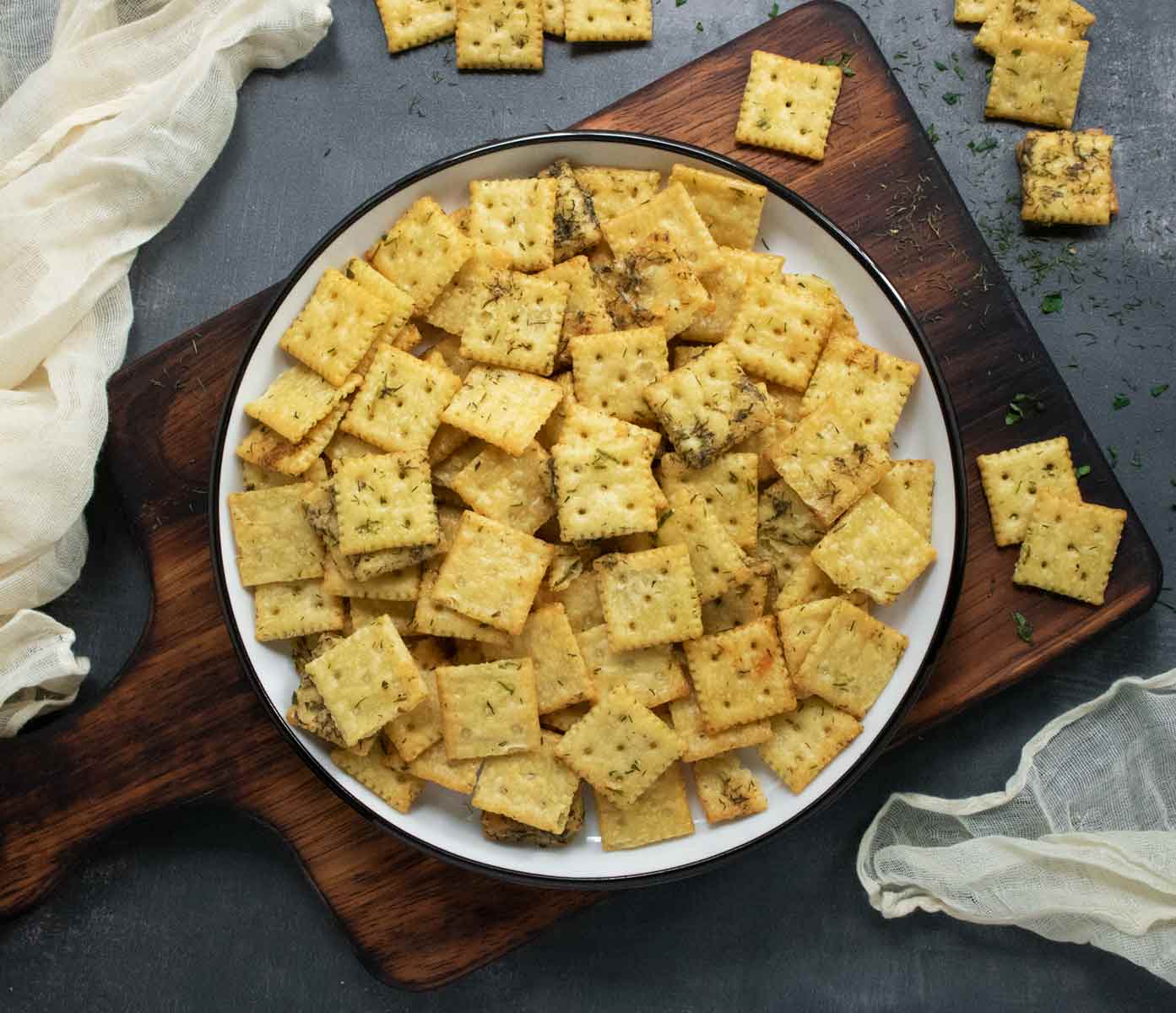 A plate of Dill Pickle Saltines on a wooden serving board.