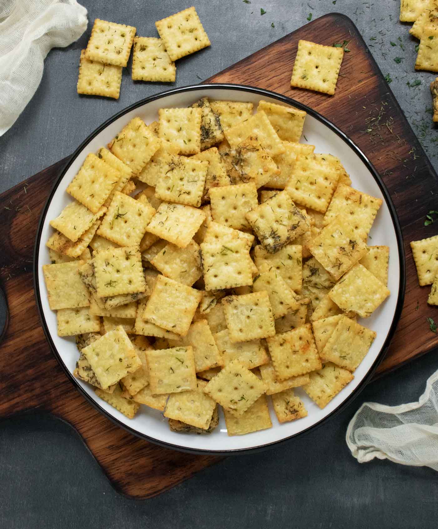 A plateful of Dill Pickle Saltines on a wooden serving board.