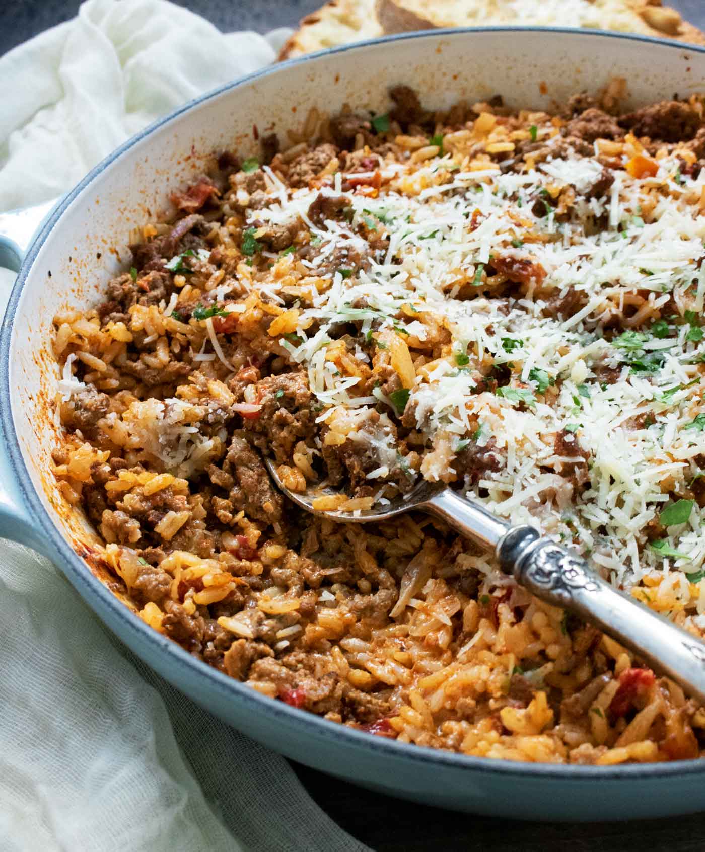 Side-angled view of Marry Me Beef and Rice in a skillet with a serving spoon.