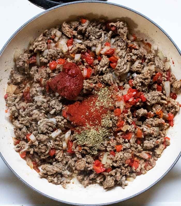 Adding the seasonings to the meat mixture.
