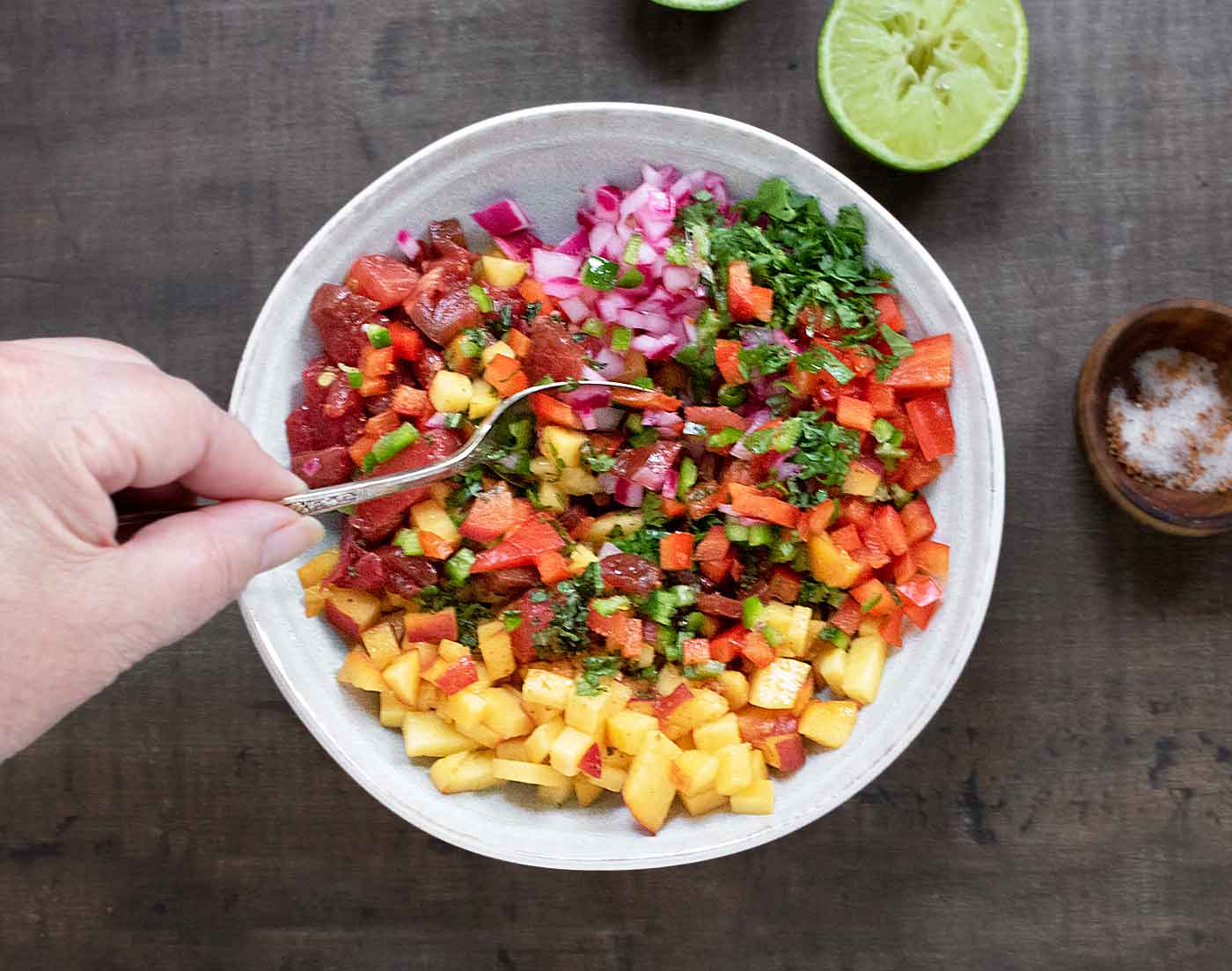 Stirring together the ingredients of peach salsa.