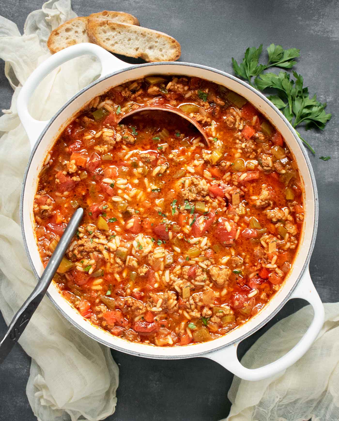 Stuffed Pepper Soup in a large white soup pot with a copper ladle.