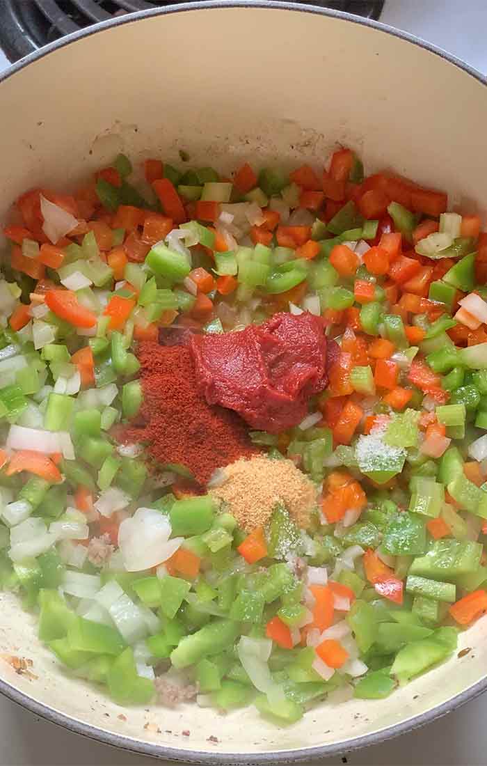 Aromatic vegetables are softened, tomato paste and seasonings on board.