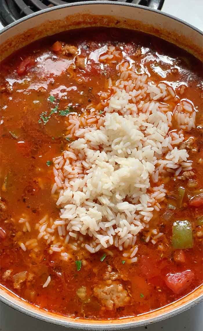 Stirring in the rice to finish the soup.