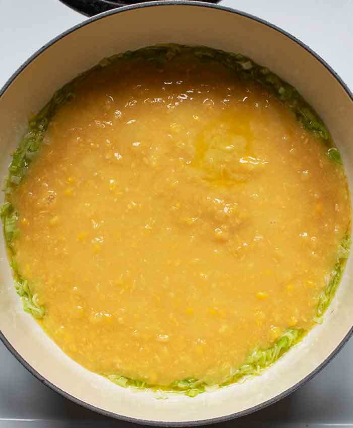 Adding creamed corn to the pot.