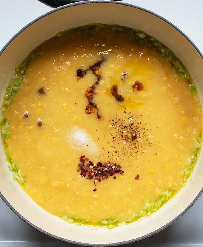 Adding seasonings to the soup.