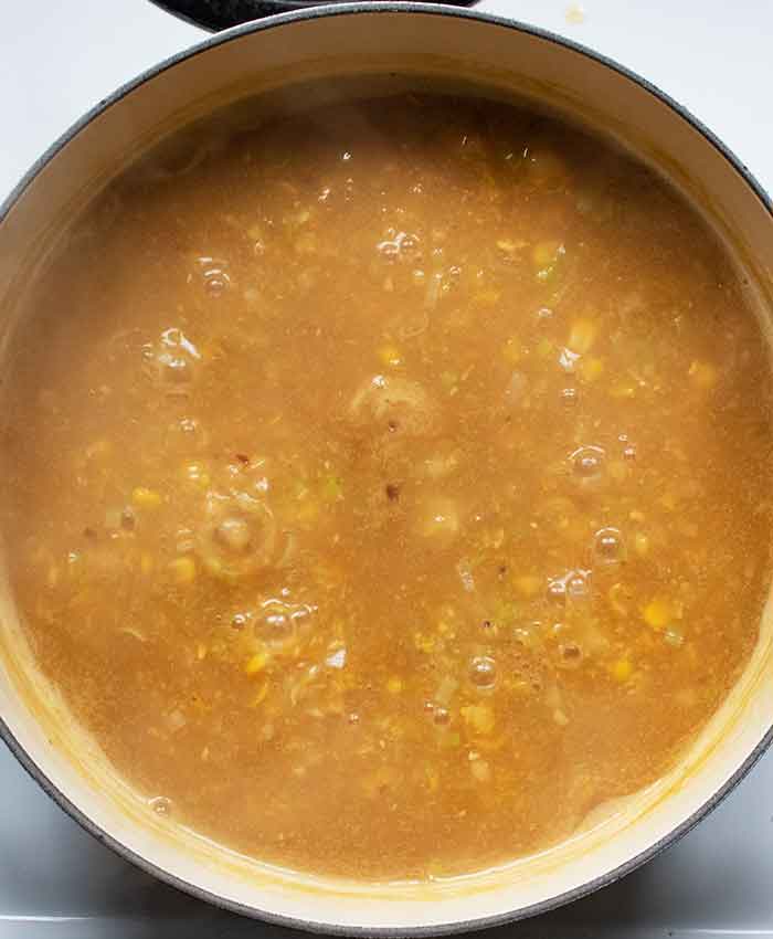 The soup coming up to a bubbly simmer.