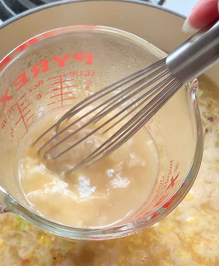 Whisking cornstarch into some of the hot broth to add to the soup.