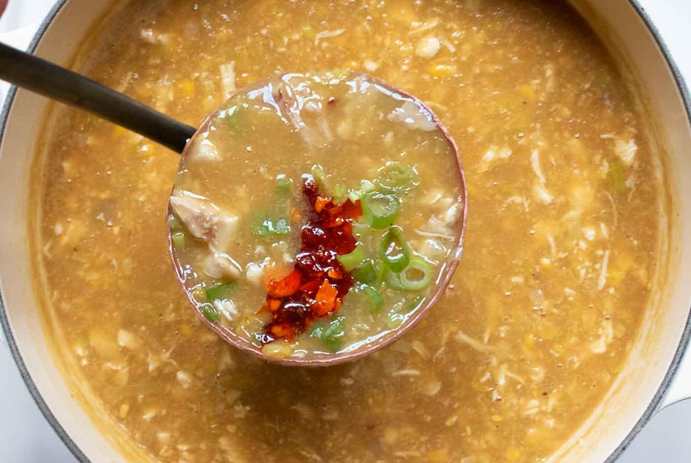 Add green onions to the finished soup and serve with your favorite spicy condiment, like chili crisp.