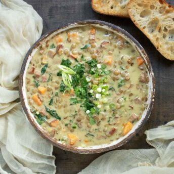 Overhead view of a bowl of Green Curry Lentil Soup with a side of toasty bread slices.