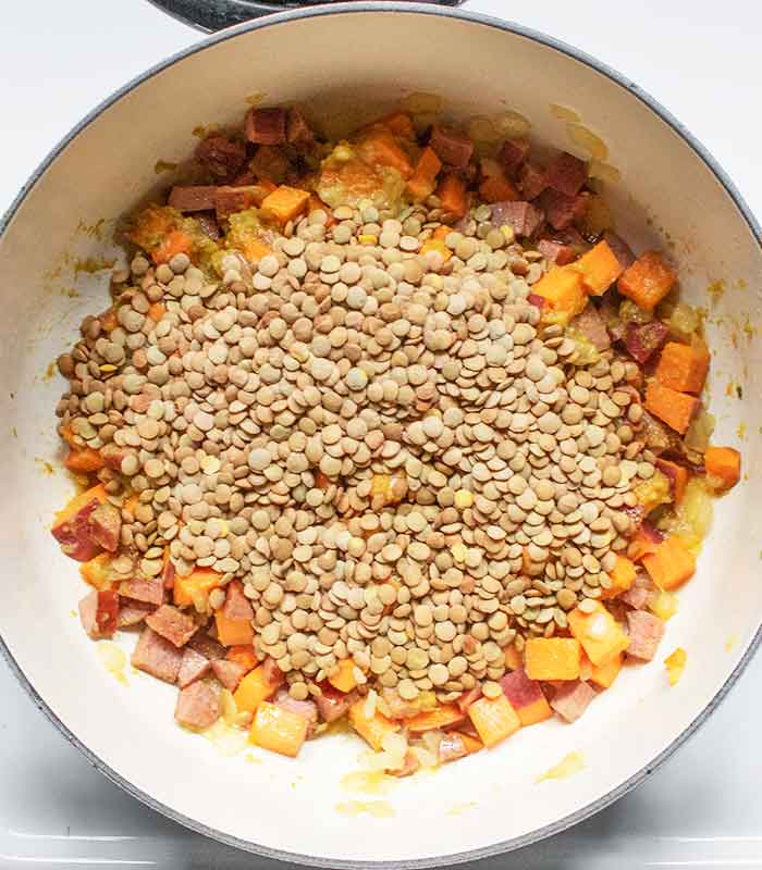 Adding the lentils to the pot.