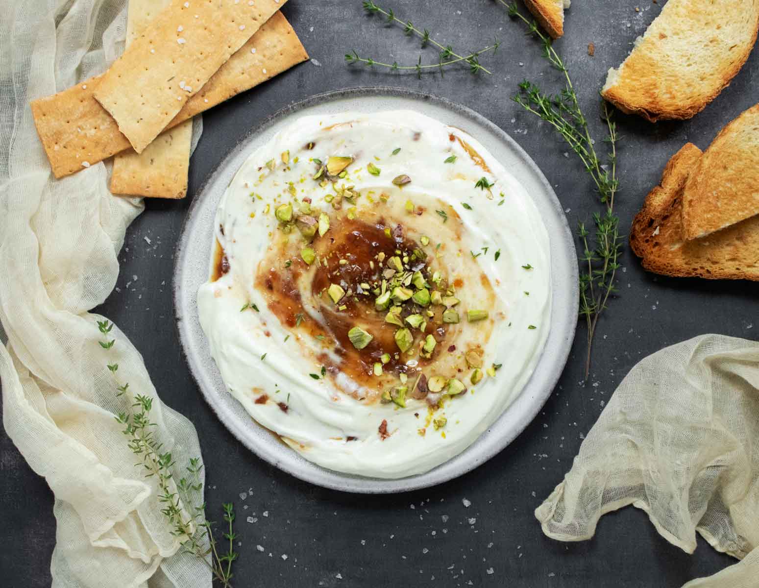 Overhead view of Whipped Ricotta with Fig Jam on a plate, and crackers on the side.
