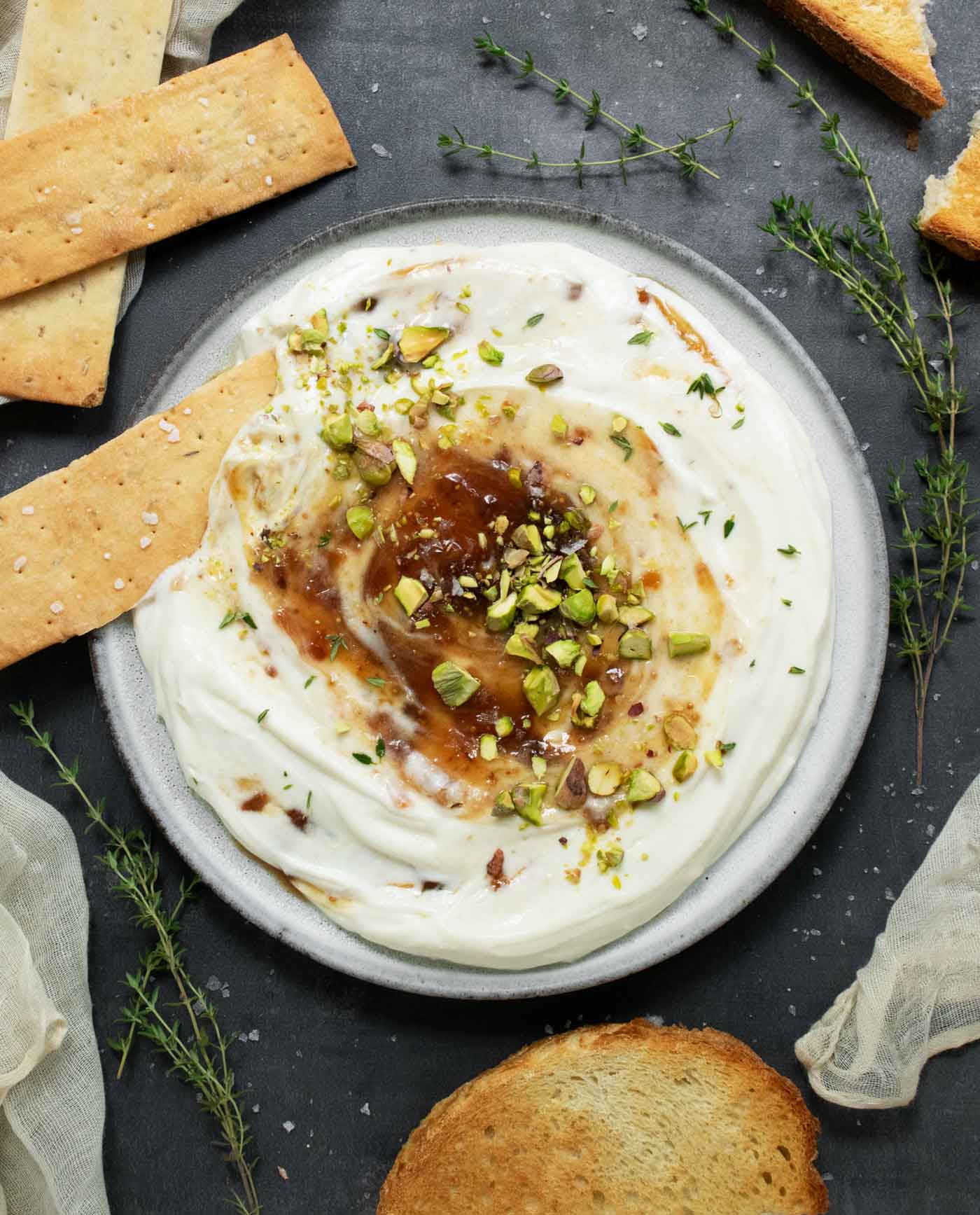 An overhead view of Whipped Ricotta with Fig Jam with a cracker dipped into it.