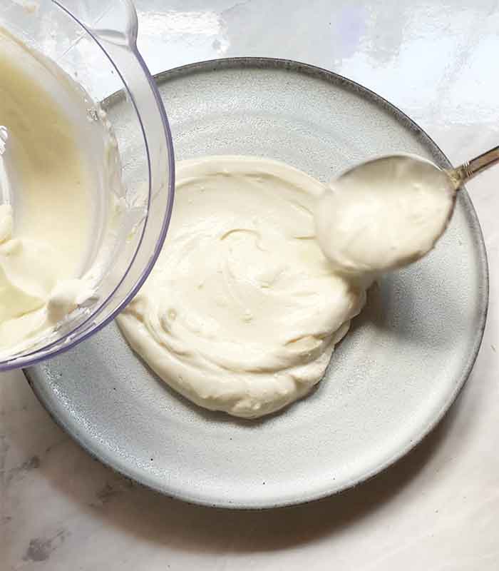Spooning the whipped ricotta out of the bowl and onto a plate.