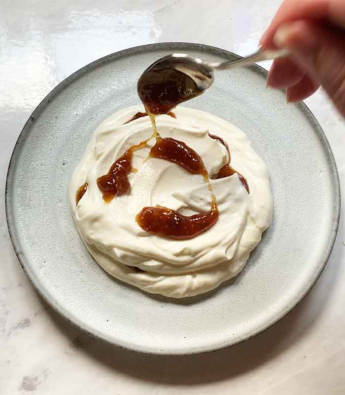 Spooning fig jam onto the ricotta.