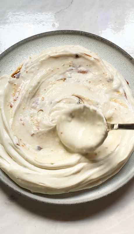 Swirling the ricotta and jam together with a spoon.