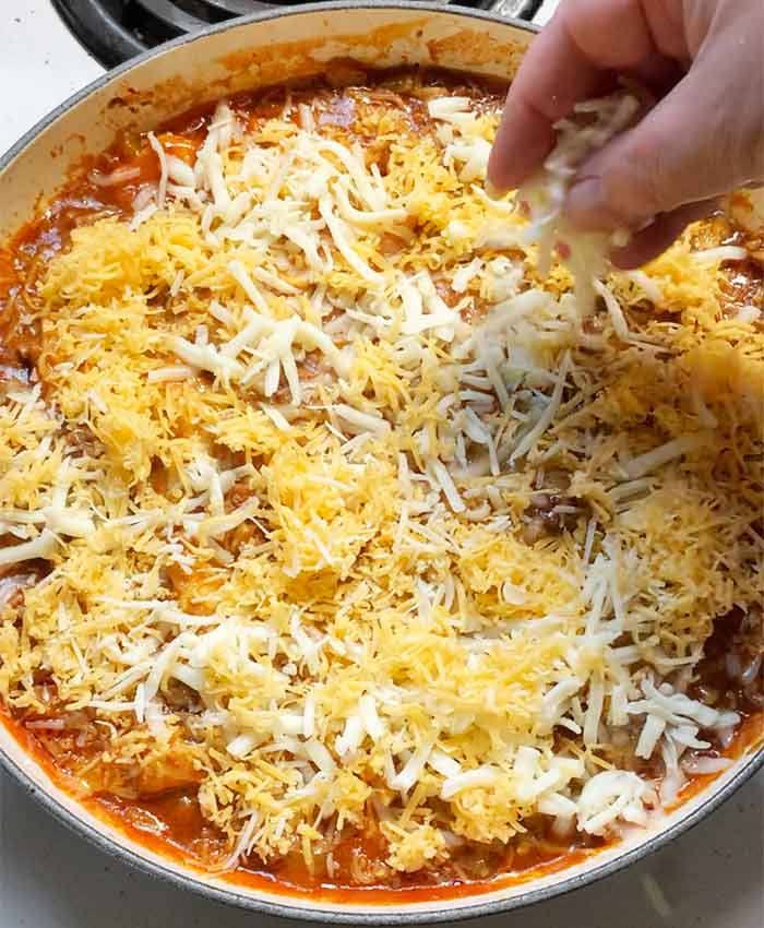 My chunky right hand again, this time spreading grated cheese over the top. Spurtle has gone to take a nap in the dishwasher.