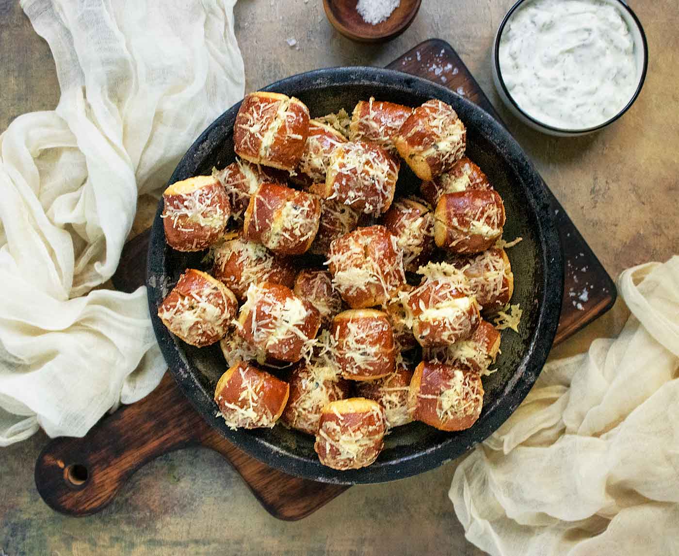 Overhead view of Cheese Stuffed Ranch Pretzel Bites on a plate with dipping sauce on the side.