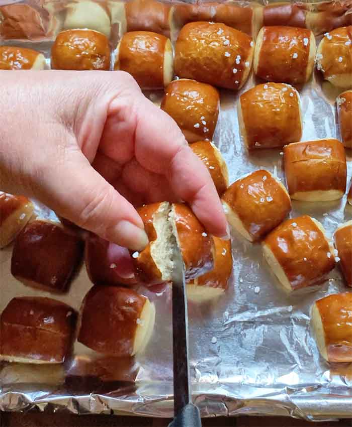 Making a small shallow slice into one pretzel bite with a paring knife.