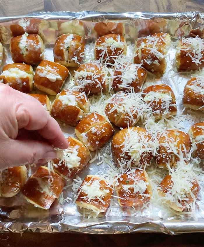Sprinkling grated parmesan cheese over the tops of the stuffed pretzel bites. Not shown, I also sprinkled flaked salt over the buttery bites because I'm extra like that.