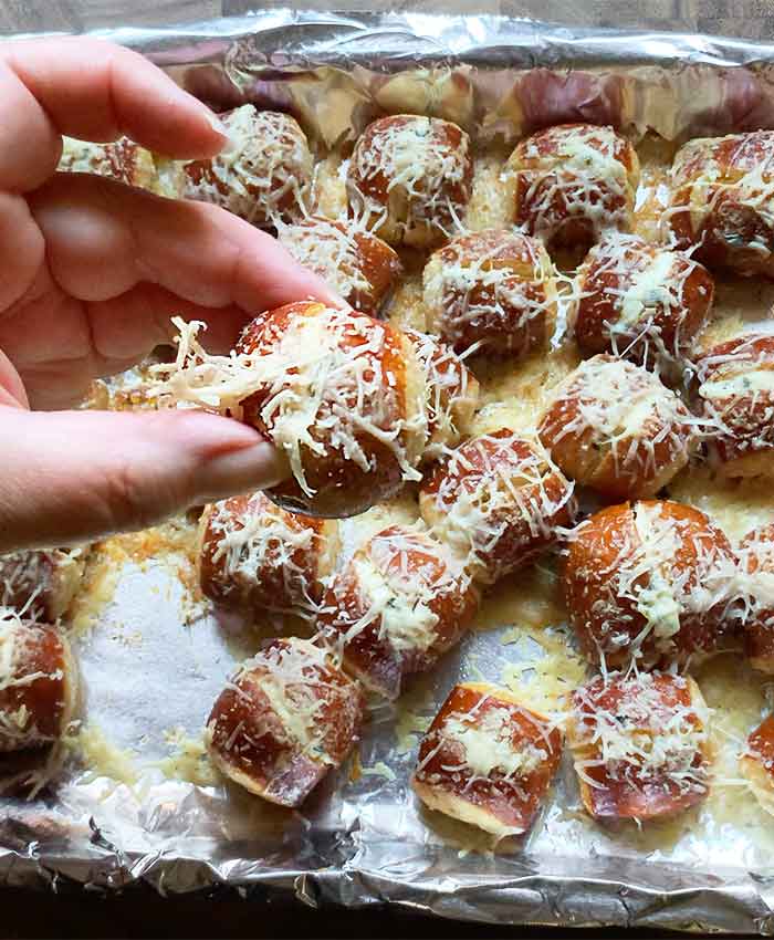 Up close photo of a freshly baked soft pretzel bite held between the fingers and thumb of my left hand. (Then I ate it. How could I not?)