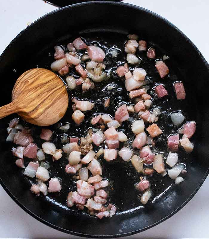 Cooking the pancetta in the skillet.