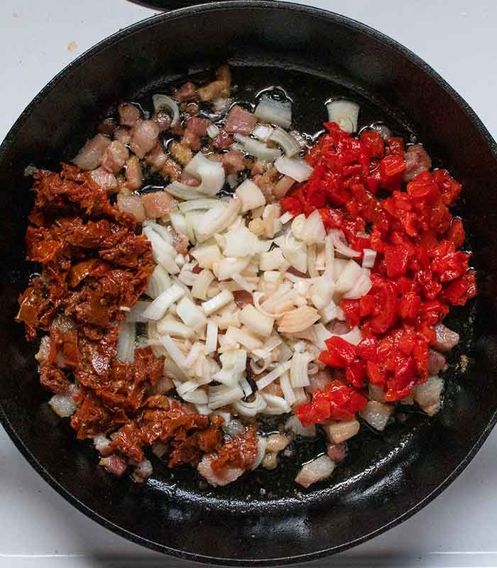 Sauteeing the aromatics and sun-dried tomatoes.