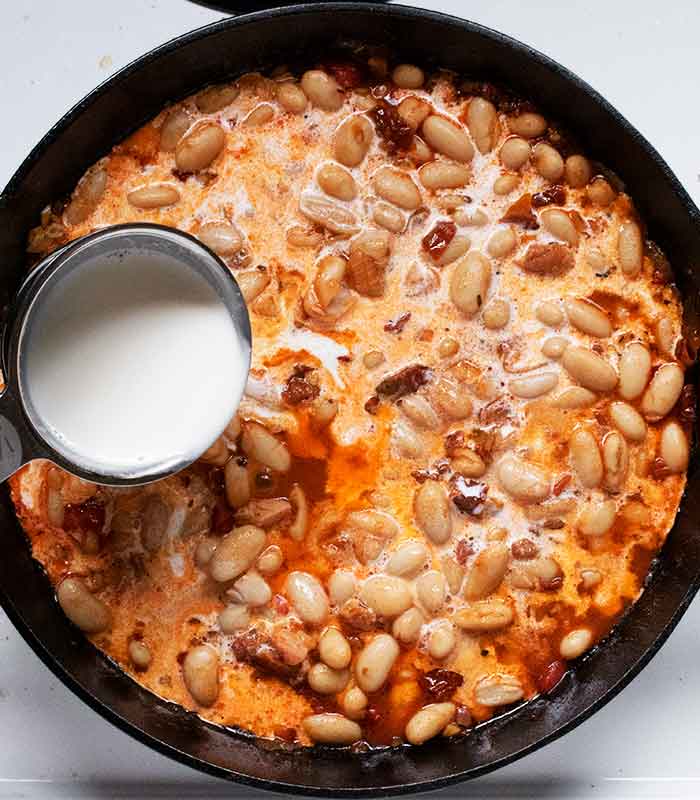 Adding the cream to the skillet.