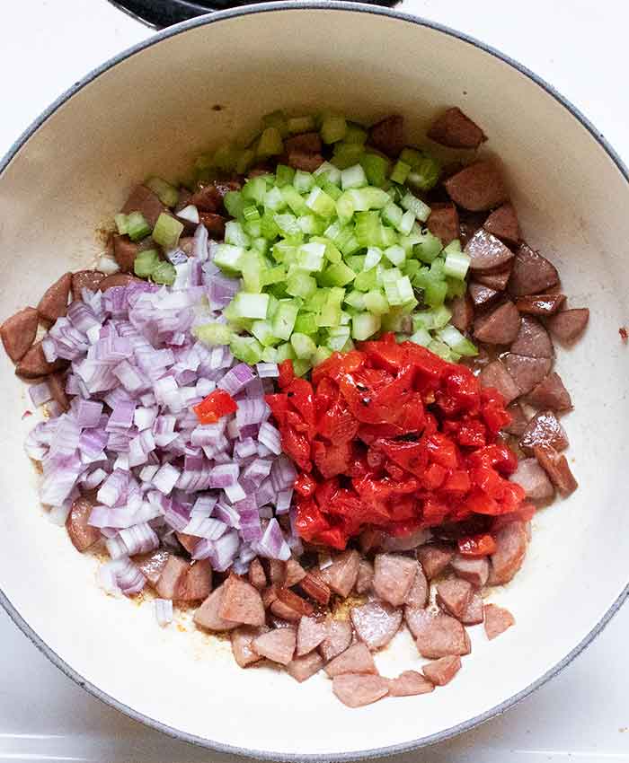 Aromatic vegetables cooking with the sausage.