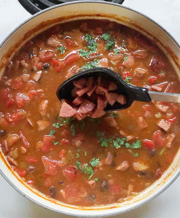 Topping the soup with some of the reserved sausage.