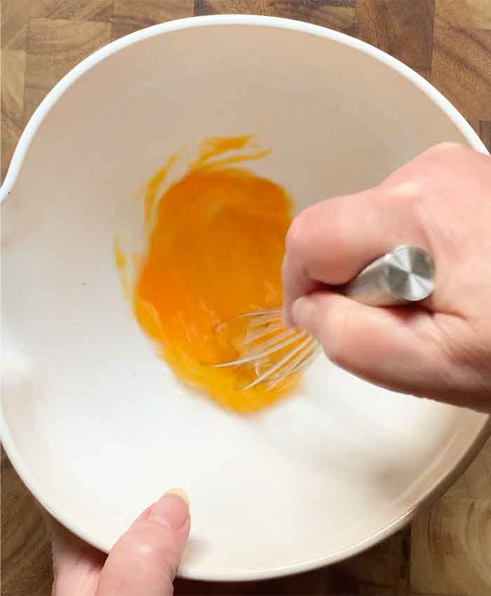 Whisking one egg in the mixing bowl.