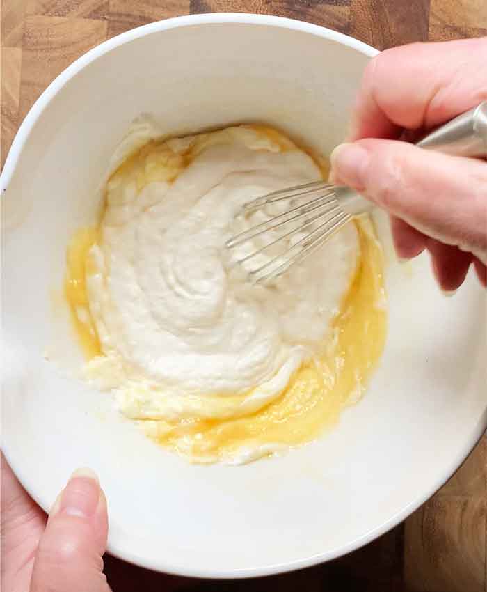 Whisking the egg with the sour cream and melted butter.