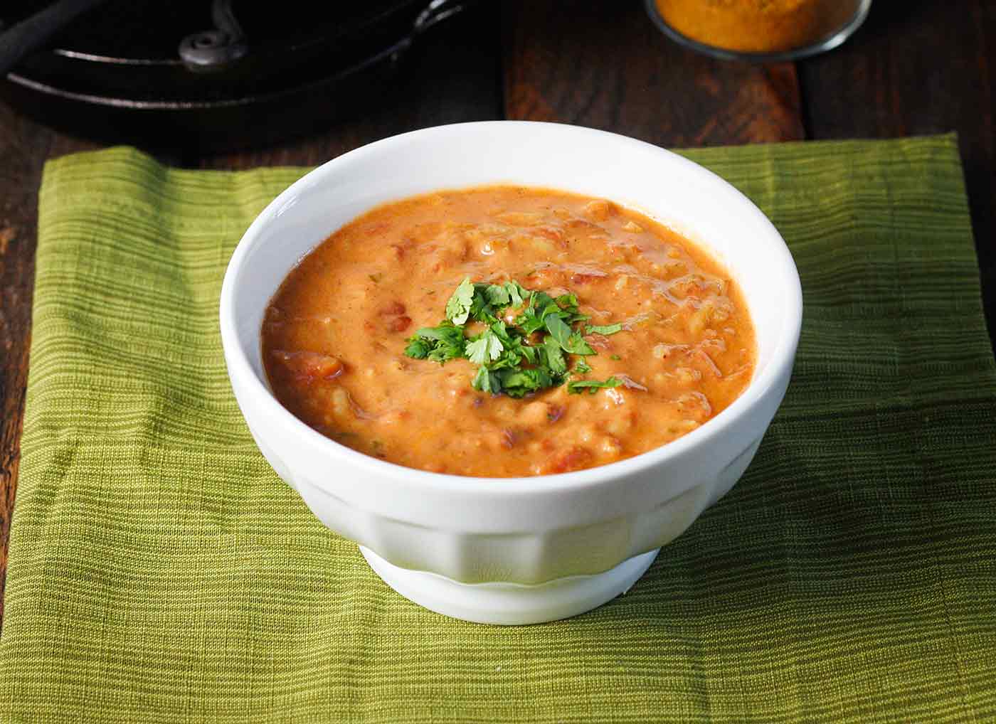 Side-angled view of Shrimp Tikka Masala Soup in a white soup bowl.