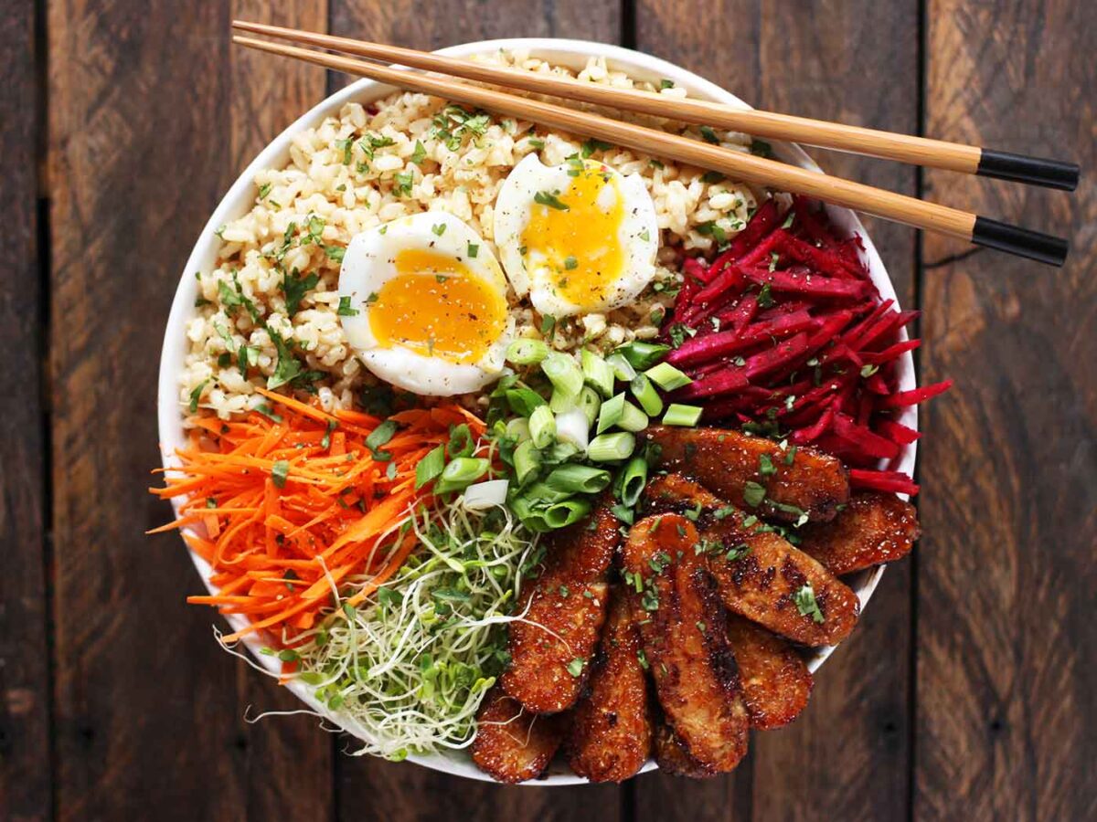 Overhead view of Smoky Tempeh Vegetable & Rice Bowl with a pair of chopsticks.