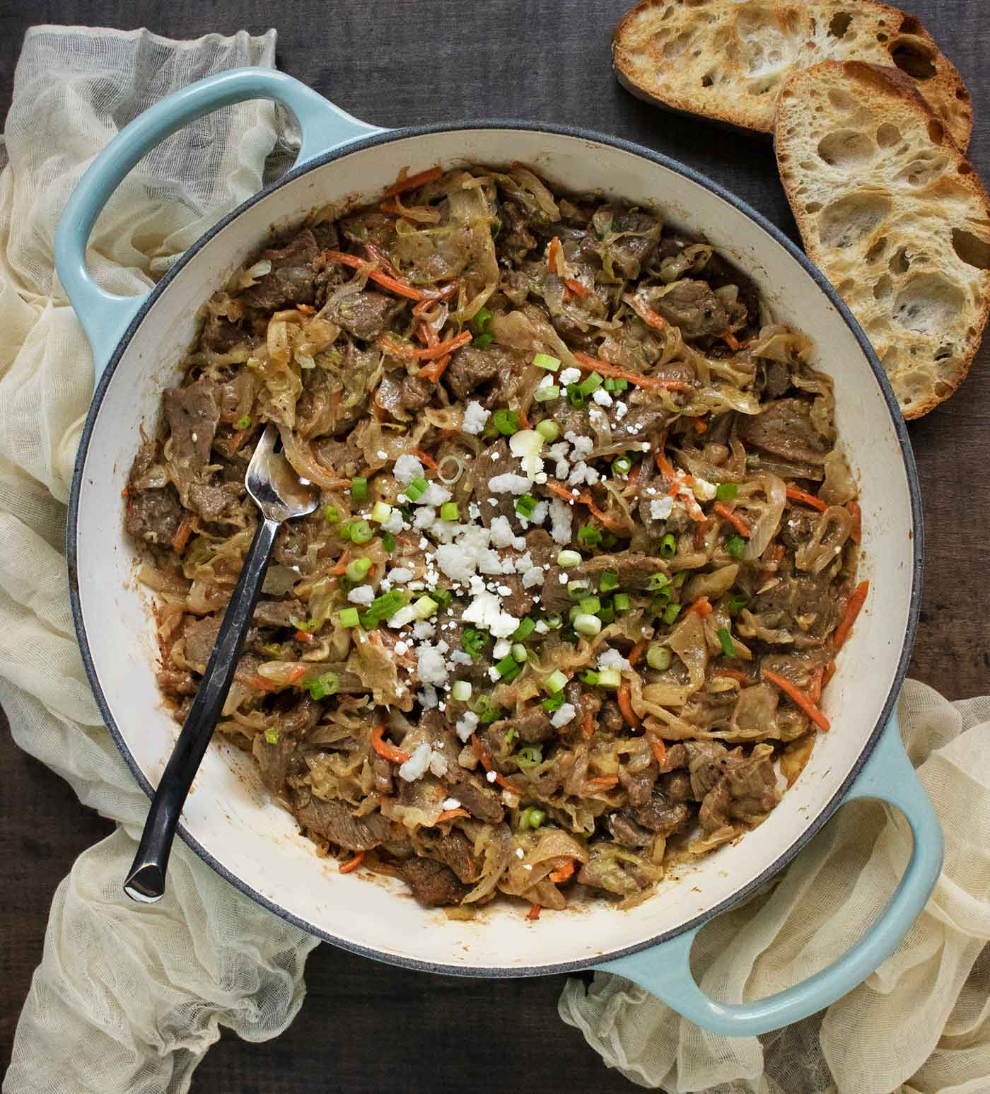Overhead view of Steak and Cabbage Skillet with a serving fork and a side of bread.