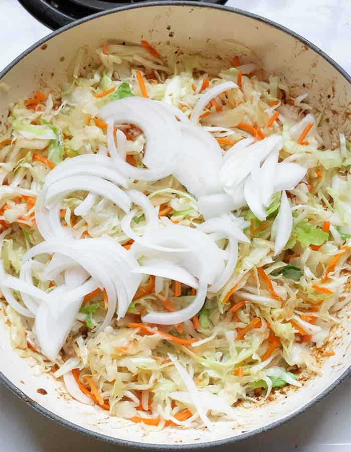 Cabbage and onions cooking in the skillet.