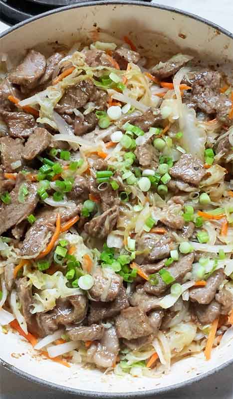Topping the dish with lots of sliced green onions.