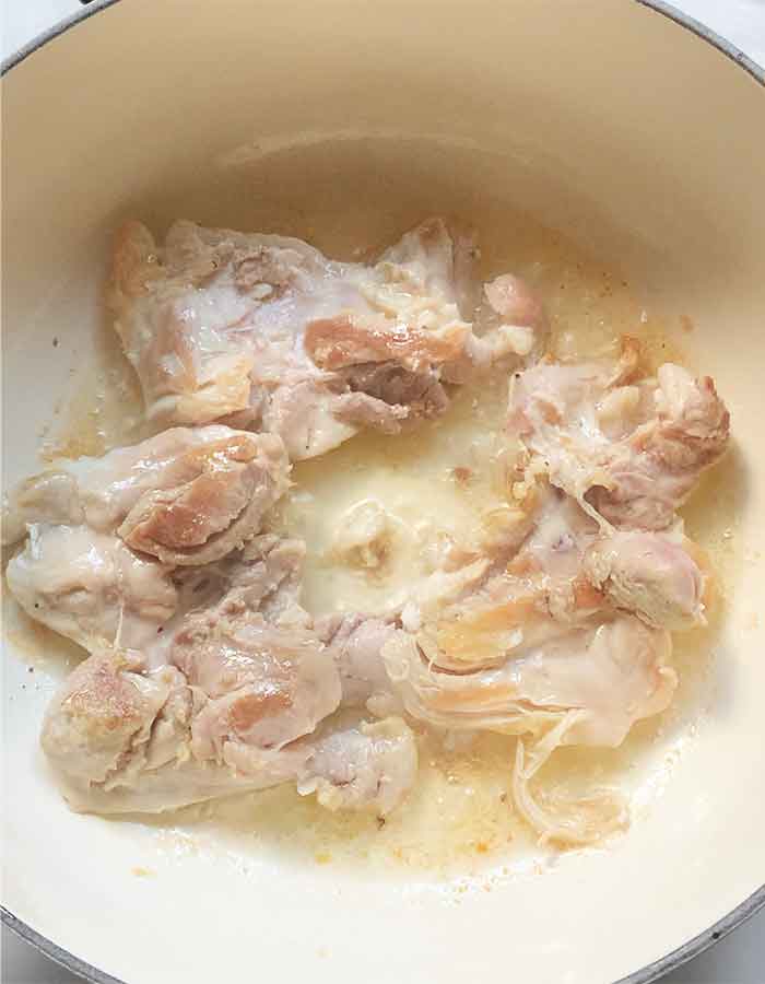 Chicken thighs cooked through and ready to move to a bowl to cool.