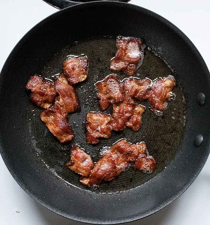 The bacon in the skillet, brown and crispy and ready to transfer to a plate.