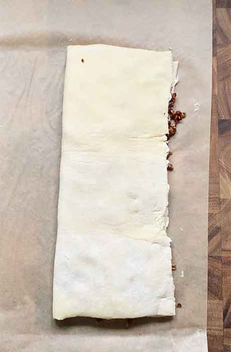 Puff pastry folded over the bacon mixture.