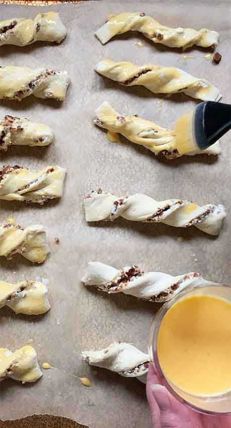 Brushing the twists with egg wash.