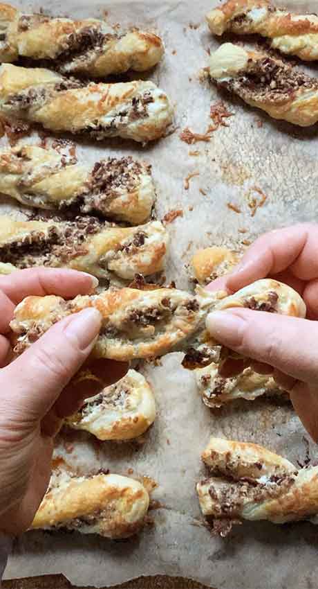 My hands holding a baked twist, ready to pull part to the show the delish insides.
